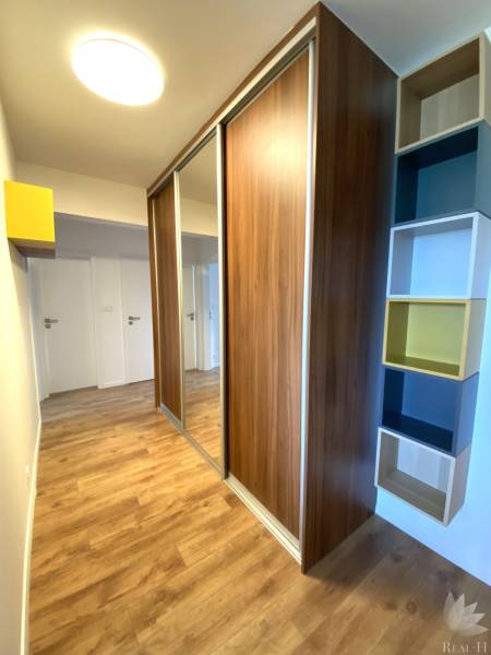 In the 3-room apartment, you can see a built-in wardrobe, a floor with a wooden decor, and shelves.