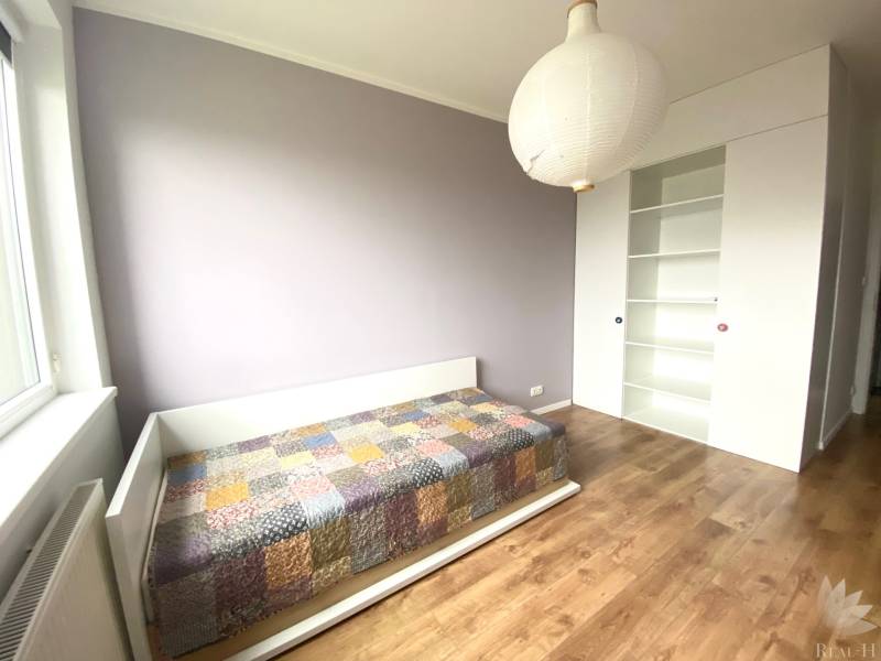 Children's room in a 3-room apartment with a bed and a floor with a wooden decor.