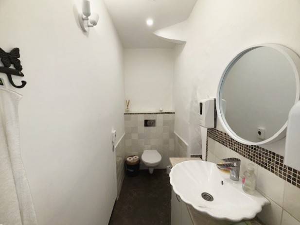 Restroom with a sink and mirror, located in commercial premises.