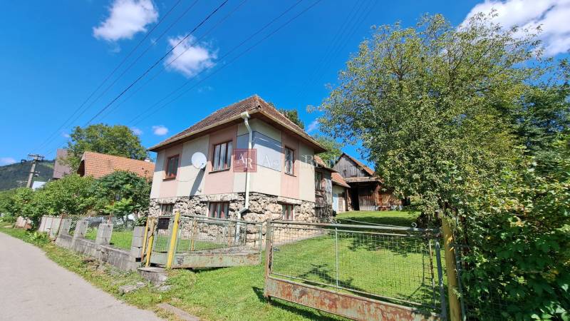 A family house on Kalameny Street in Ružomberok surrounded by greenery and blue skies.