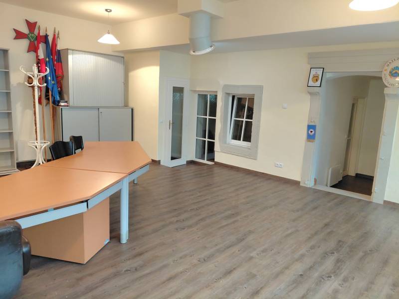 Offices with wood-patterned flooring, a desk, and cabinets.