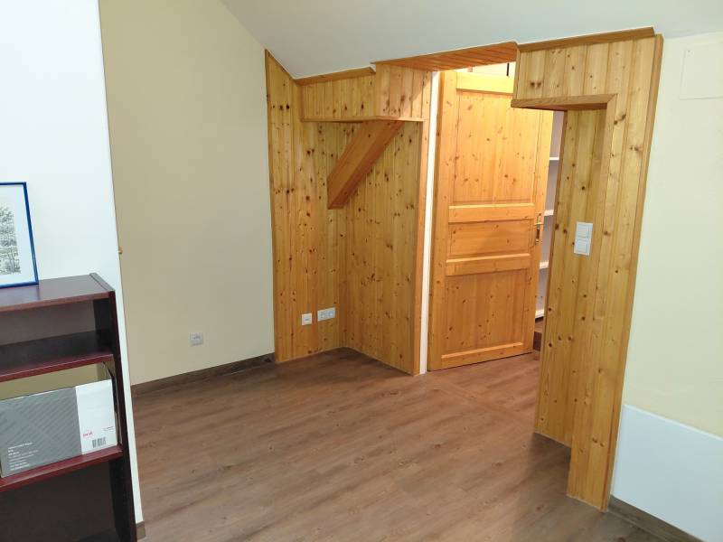 Interior of an office with wooden paneling and a wood-patterned floor.