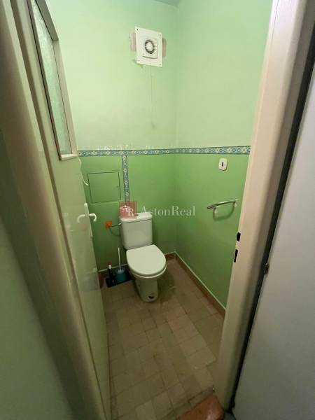 Bathroom in a 3-room apartment with a toilet and ventilation system, green walls.