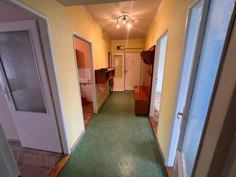 A hallway in a 3-room apartment with linoleum and colored walls.