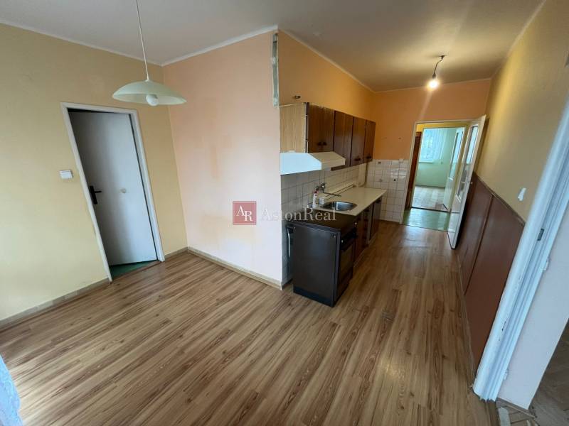 Kitchen and dining area in a 3-room apartment with a wooden decor floor.