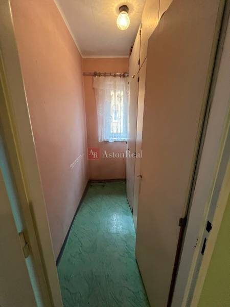 A narrow room with a built-in wardrobe and a curtain in a 3-room apartment.