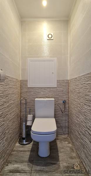 Bathroom with toilet and tiles in a 2-room apartment, with ceramic flooring.