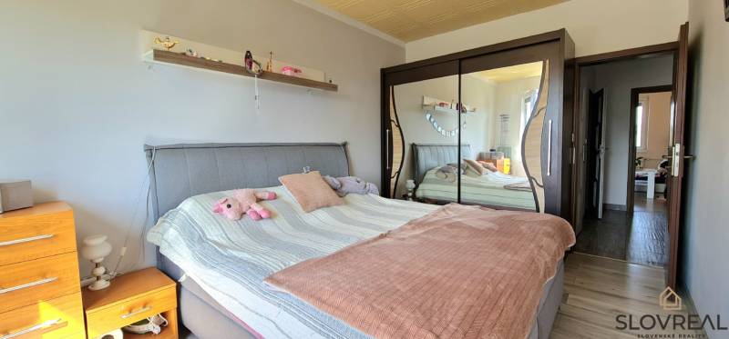 A bedroom in a two-room apartment with a mirrored wardrobe and an upholstered bed.