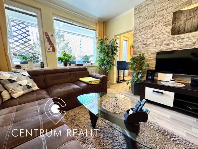 Living room in a one-room apartment with a brown sofa and a wooden decor floor.