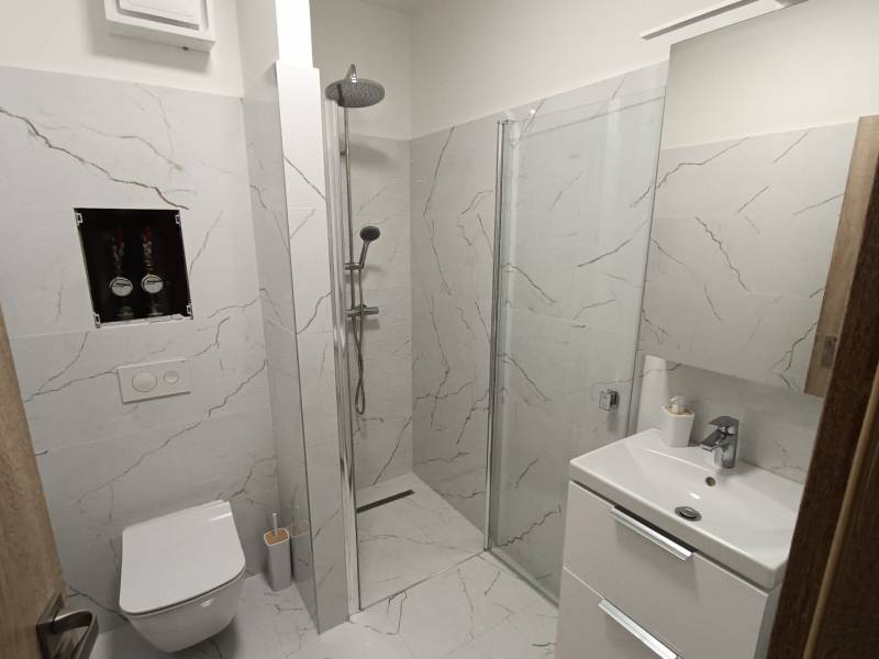 A bathroom in a 2-room apartment with a thoughtfully designed shower and modern equipment.