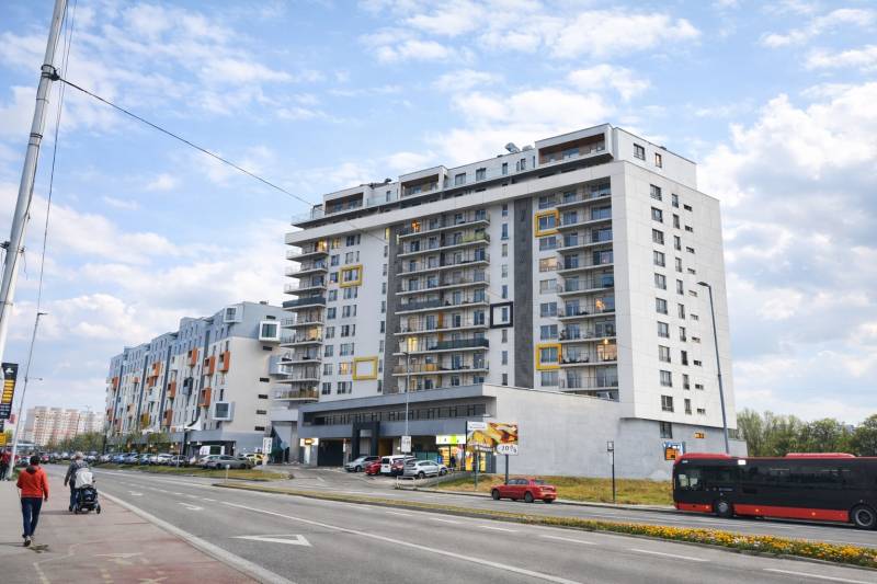 Apartment buildings on Rusovská Road in Bratislava - Petržalka, next to the road and sidewalk.