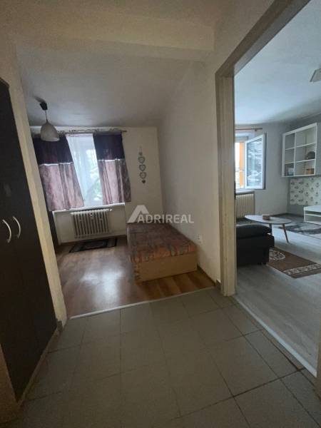 Interior of a 1-room apartment with a bed and wooden decor flooring.