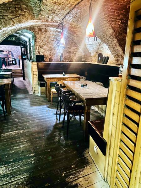 Stone walls and a wooden-patterned floor create a cozy atmosphere in the dining area.