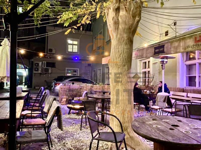 Exterior Gastro spaces on Sedlárska Street in Bratislava - Historic core with wooden seating.