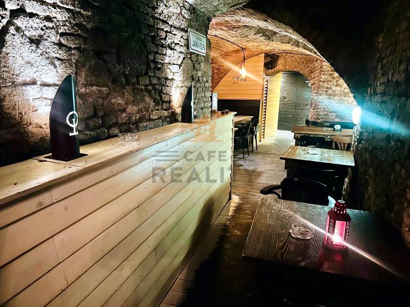 Stone walls and arches in dining areas with wood-patterned flooring.