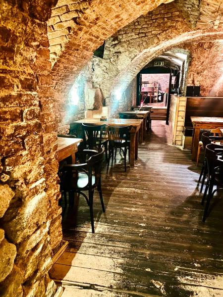 Stone arches, wooden tables, and a wooden decor floor in dining areas.