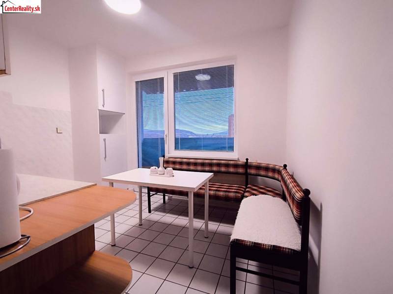 A kitchen with a corner bench, table, and window in a 2-room apartment.