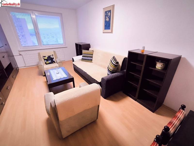 Living room in a two-room apartment with comfortable seating and a wooden decor floor.