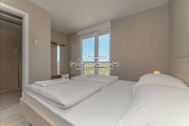 Bright bedroom with a double bed and access to a bathroom in the Holiday Apartment.