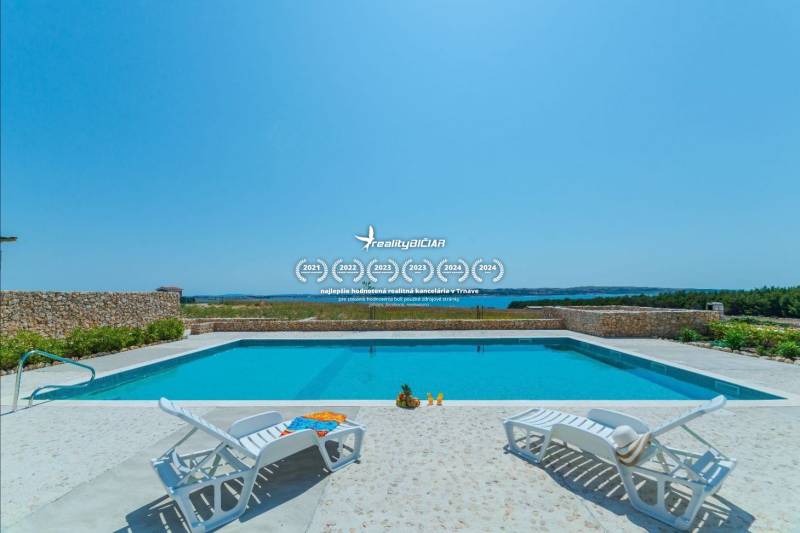 A swimming pool with loungers in a holiday apartment in Povljane offers a sea view.