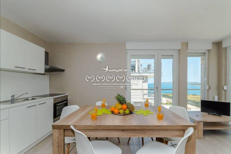 Holiday apartment with sea view, dining table, and kitchenette.
