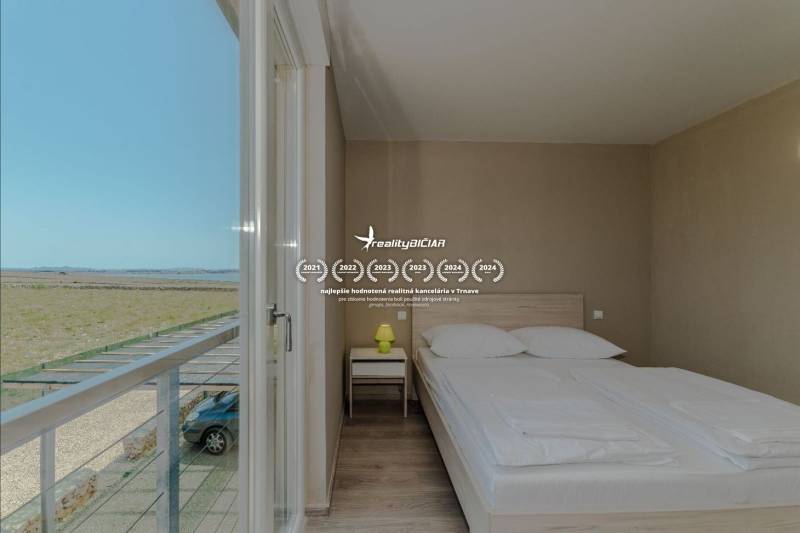 Bedroom in a holiday apartment with a view, bed, and wooden decor flooring.