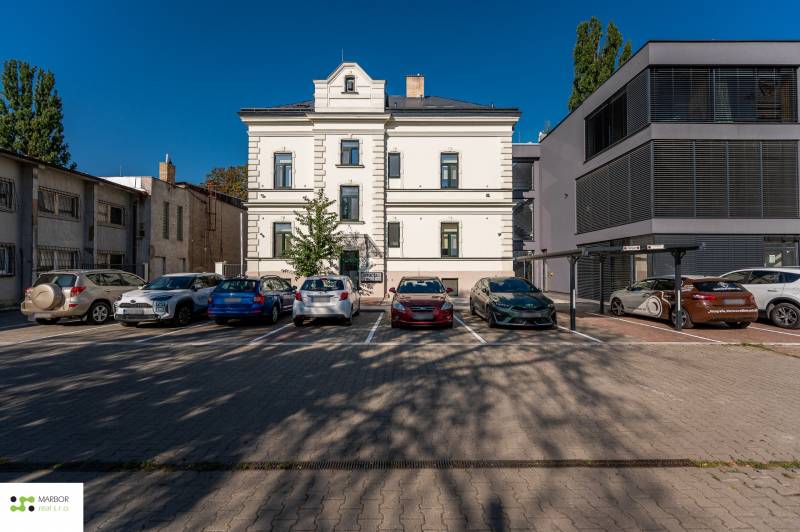 A parking lot with cars and a building on Južná trieda, Košice - Juh district.