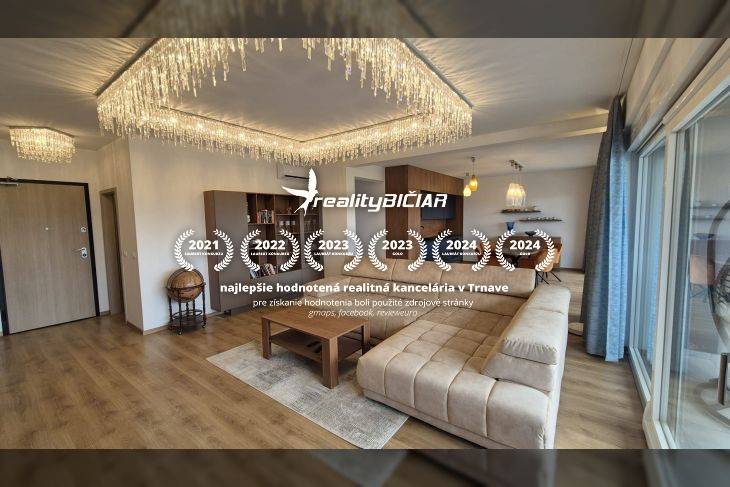 Living room in a holiday apartment with wood-patterned flooring, a sofa, and pendant lights.