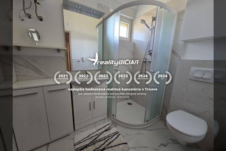 Bathroom in a holiday apartment with a modern shower and white furniture.