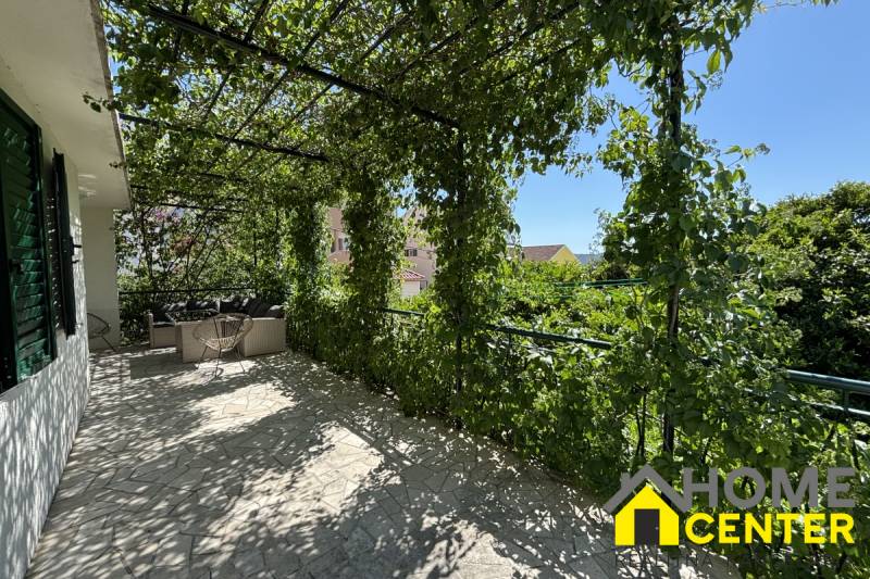 Terrace of a family house in Čiovo with a pergola covered in greenery and outdoor seating.