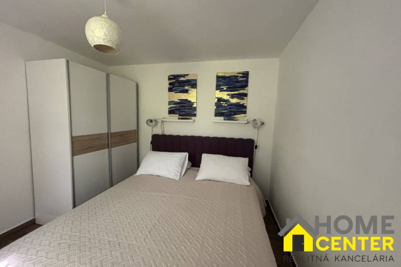 A bedroom in a family house with a double bed, a wardrobe, and wall decorations.