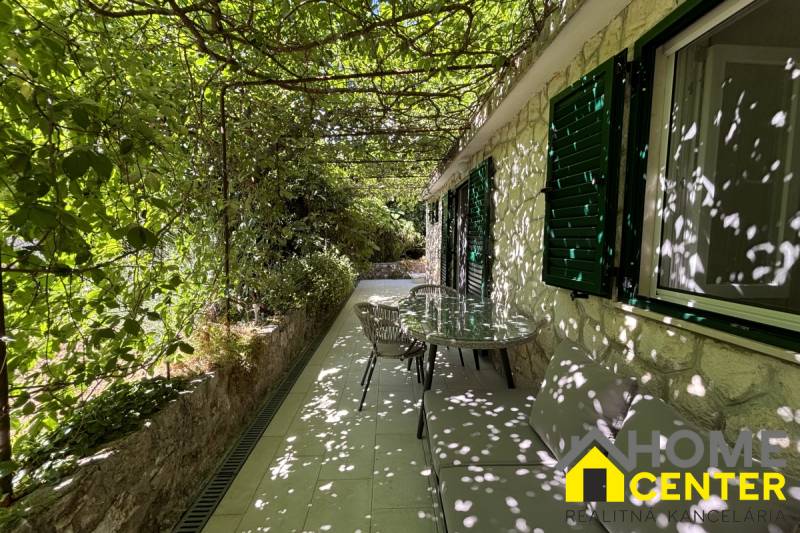 A covered terrace of a family house in Čiovo with climbing plants and outdoor seating.