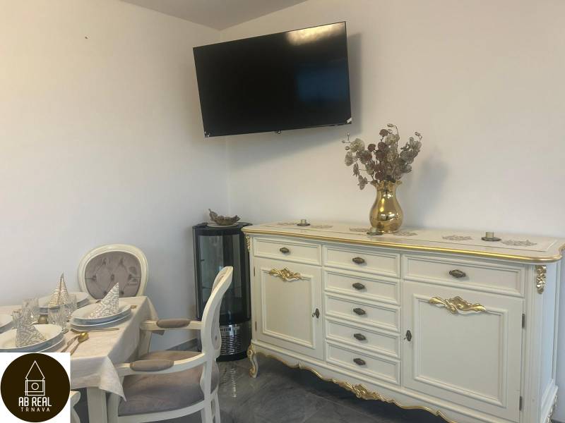 Elegantly furnished interior of dining spaces with a television on the wall and decorated furniture.