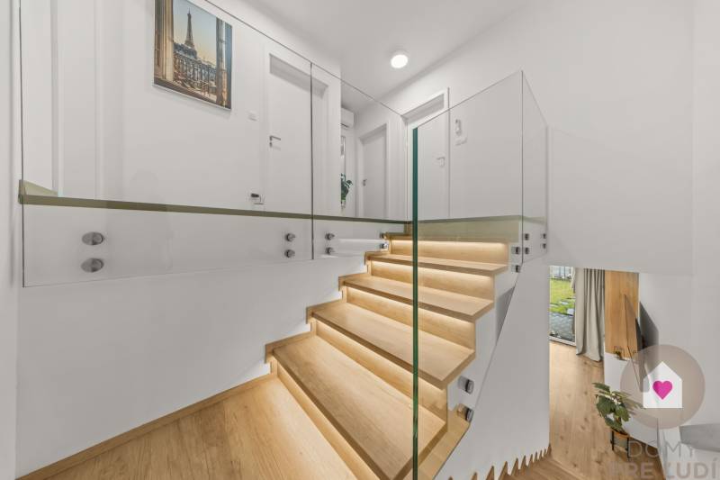 Glass railing and stairs with wood-decor flooring in a 4-room apartment.
