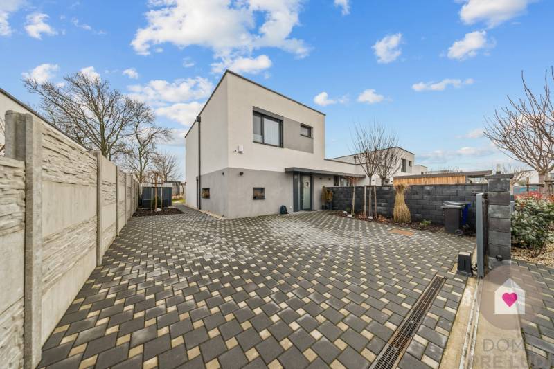 A family house on Topoľová Street in Rovinka with a paved courtyard and fencing.