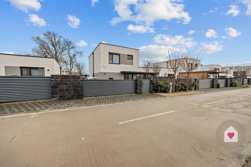 New buildings with a garage on Topoľová Street in Rovinka, surrounded by a modern fence.