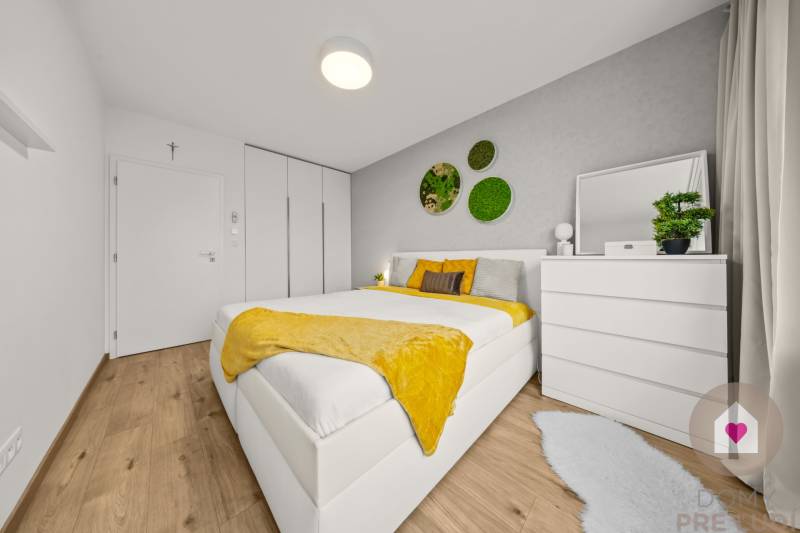 Bright bedroom with a bed, white furniture, plants, and wood-patterned flooring in a 4-room apartment.