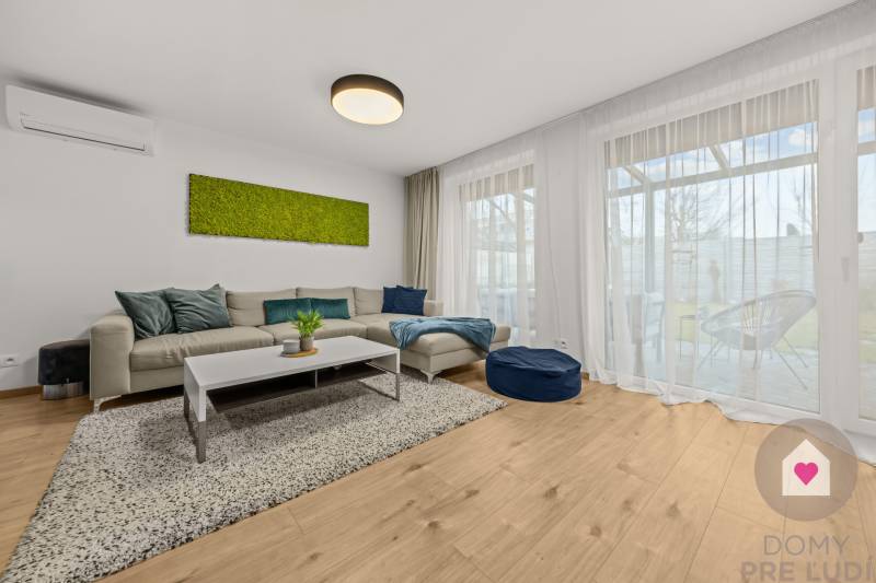 Living room in a 4-room apartment with a comfortable sofa and a floor with a wooden decor.