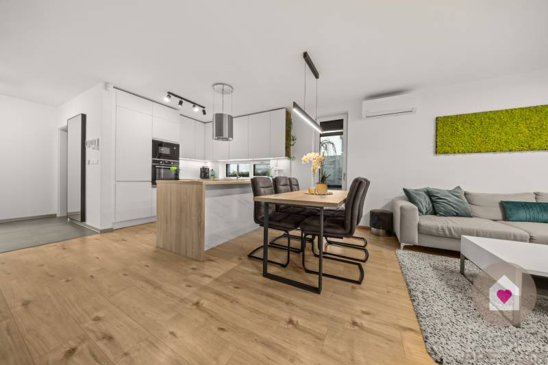 The kitchen in a 4-room apartment with a wooden decor floor and a dining table.