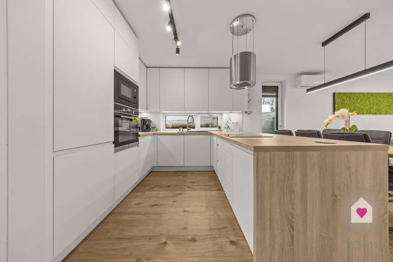A kitchen with built-in appliances and an island, a floor with a wooden decor in a 4-room apartment.