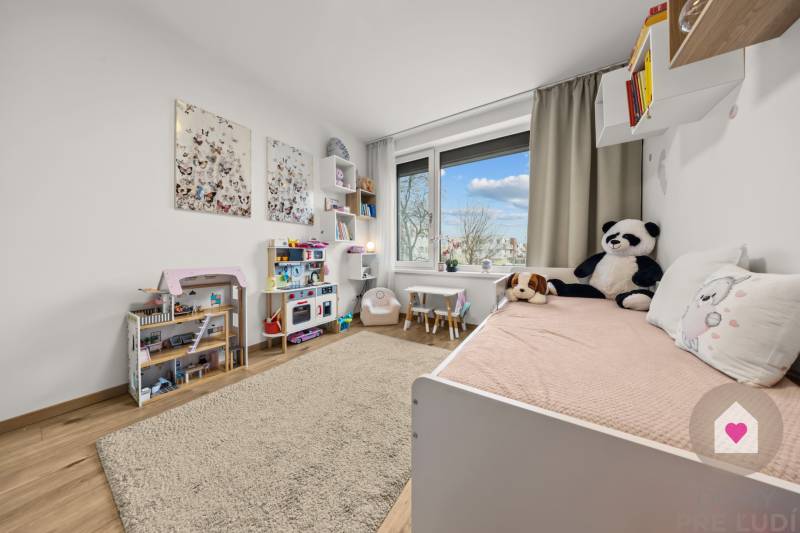 Children's room in a 4-room apartment with a wooden decor floor, plush toys, and toys.