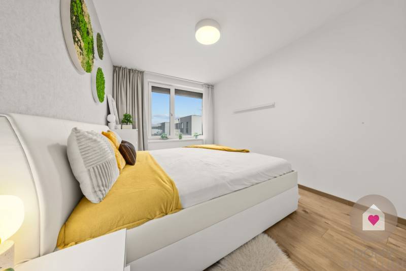 A bedroom in a 4-room apartment with a bed, yellow accessories, and a wooden decor floor.