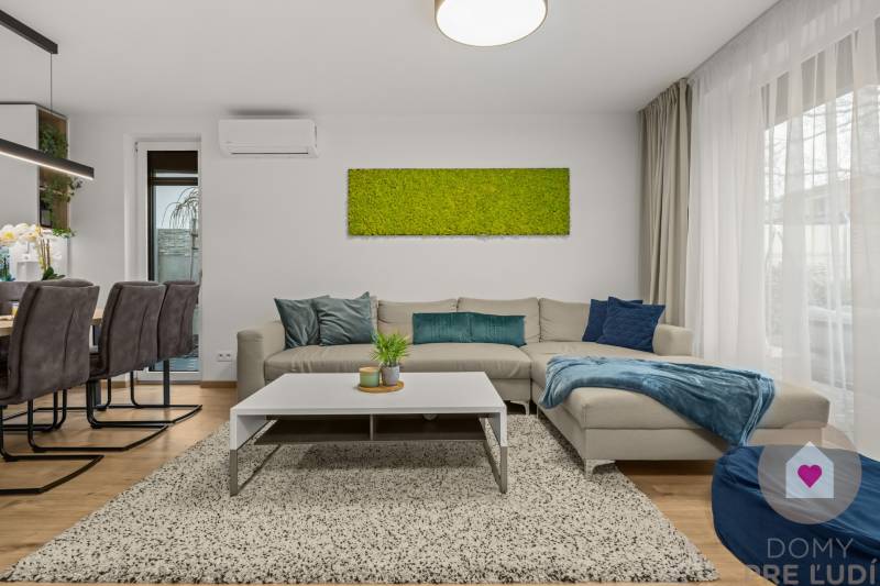 Living room with a gray sofa, green painting, and wooden decor flooring in a 4-room apartment.