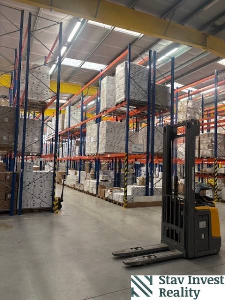 In warehouses and halls, we see tall racks with pallets and a forklift.