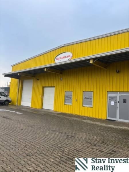 Yellow warehouse and hall building on Poľná cesta in Senec with entrance gates.