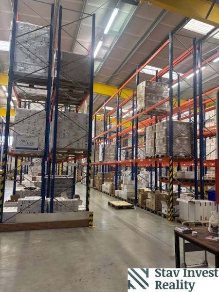 Shelves in warehouses and halls full of stored goods on pallets.