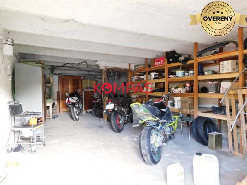 Garage in commercial premises with storage shelves and parked motorcycles.
