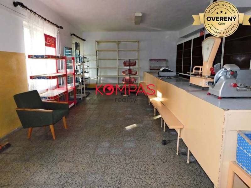 Interior of commercial premises with a counter, shelves, and an armchair.