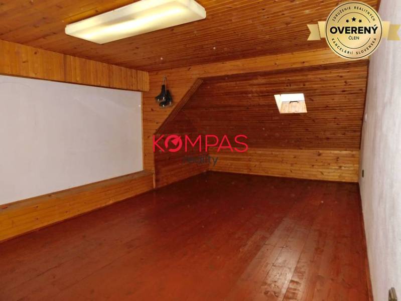 Attic space with wooden decor in commercial premises, with a small skylight.