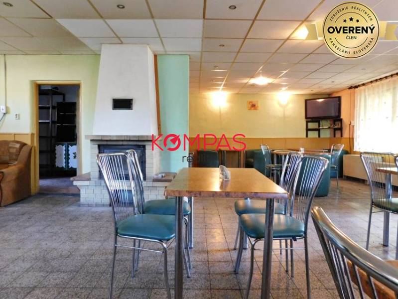 Commercial space with stylish chairs, table, and fireplace, suitable for events.